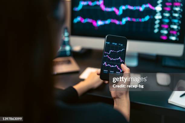 young woman doing cryptocurrency business trading on her computer at home at nigh - stock market volatility stock pictures, royalty-free photos & images