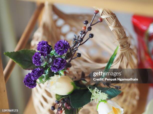 purple and yellow roses in a woven bamboo basket - basket weaving stock pictures, royalty-free photos & images