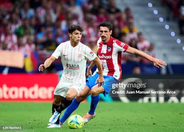 Stefan Savic of Club Atletico de Madrid duels for the ball with Oliver Torres Munoz of Sevilla FC during the LaLiga Santander match between Club...