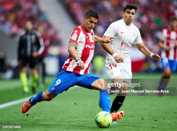 Luis Suarez of Club Atletico de Madrid duels for the ball with Marcos Acuna of Sevilla FC during the LaLiga Santander match between Club Atletico de...