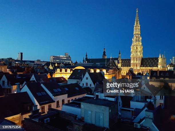 brussels at the blue hour, a view of the illuminated tower of the hotel the ville / grand-place and rooftops - bruselas fotografías e imágenes de stock