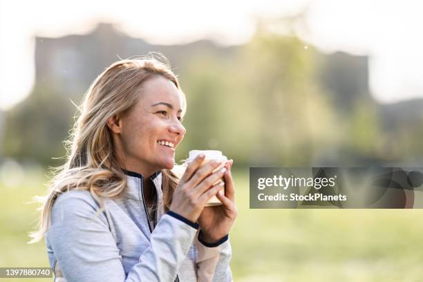 woman holding coffee cup in nature - disposable cup stock pictures, royalty-free photos & images