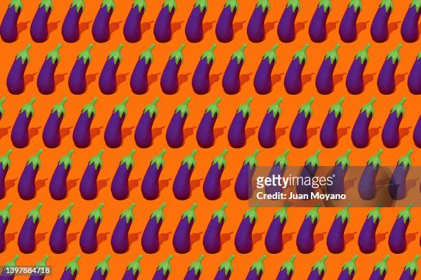 fake eggplants on an orange background - aubergine emoji stock pictures, royalty-free photos & images