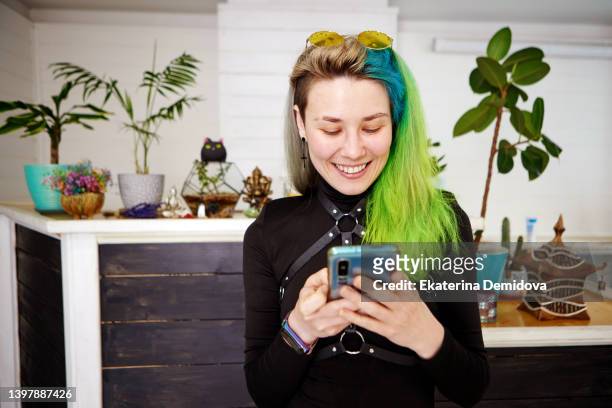 woman with smartphone and unusual hairstyle - real people lifestyle photos et images de collection