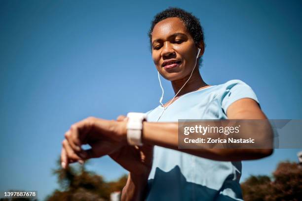smiling woman checking heart rate after sports training - computador utilizável como acessório imagens e fotografias de stock