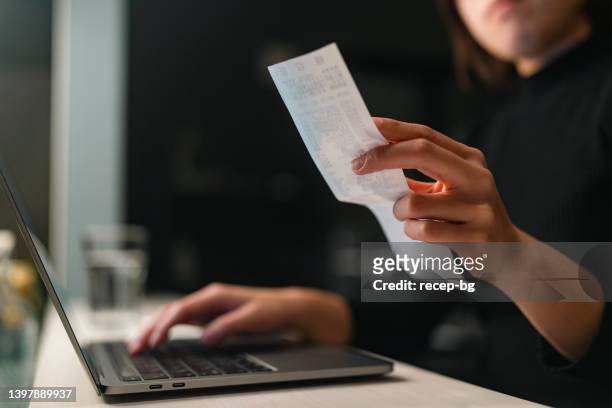 close-up photo of woman`s hands doing financial planning and checking receipts at home - receipts stockfoto's en -beelden