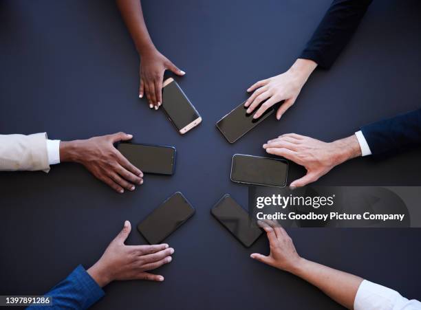 diverse businesspeople sitting with their smart phone in a circle - bring your own device stockfoto's en -beelden