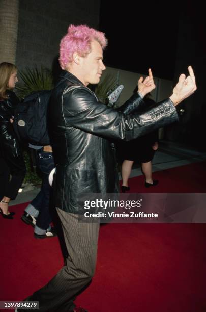 Australian-born American musician and actor Flea , with pink hair, giving the middle finger at the 1999 Billboard Music Awards, held at the MGM Grand...