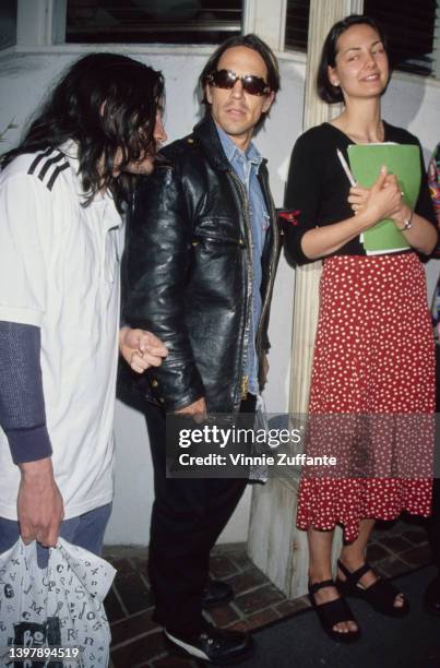 American singer, songwriter and musician Anthony Kiedis, between two people, attends the launch party for 'You Can Save the Animals: 251 Ways to Stop...