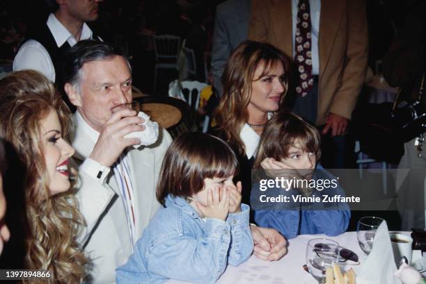 American model Rhonda Adams beside American magazine publisher Hugh Hefner and his wife, American model and actress Kimberley Conrad and their sons,...