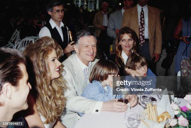 American model Rhonda Adams beside American magazine publisher Hugh Hefner and his wife, American model and actress Kimberley Conrad and their sons,...