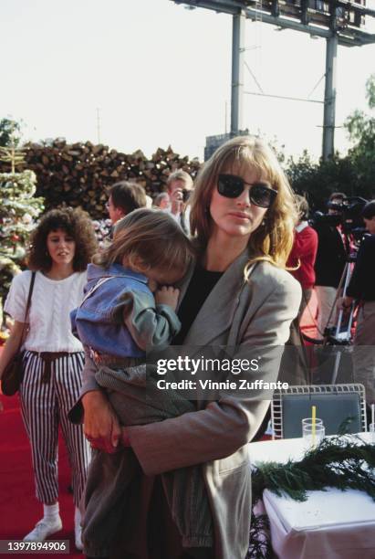 American model and actress Kimberley Conrad holding her son, Marston Hefner, attends the inaugural Spago Christmas Party for the 'Toys for Totskis...