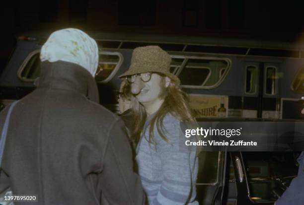 British singer and songwriter Ozzy Osbourne, wearing a blue striped cardigan with a brown hat and a pair of 'nose glasses' which feature a penis over...