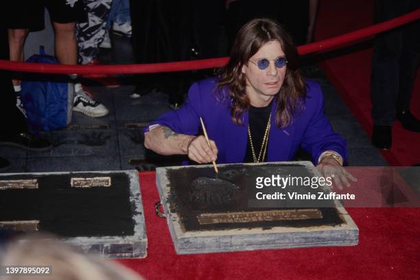 British singer and songwriter Ozzy Osbourne leaves his handprints as the original line-up of Black Sabbath is inducted into the RockWalk of Fame, at...