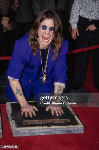 British singer and songwriter Ozzy Osbourne leaves his handprints as the original line-up of Black Sabbath is inducted into the RockWalk of Fame, at...