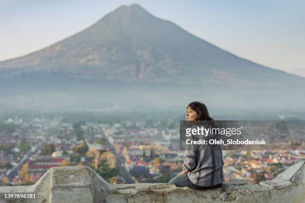 woman sitting on the background of   volcano in guatemala - central america stock pictures, royalty-free photos & images
