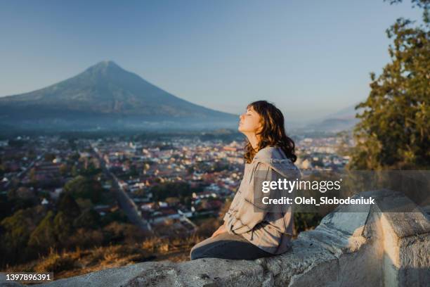 woman sitting on the background of   volcano in guatemala - volcán de fuego guatemala stock pictures, royalty-free photos & images