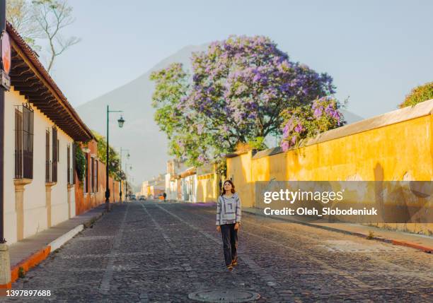 woman walking in antigua - guatemala city skyline stock pictures, royalty-free photos & images