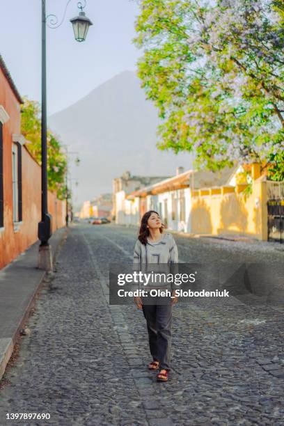 woman walking in antigua - guatemala city skyline stock pictures, royalty-free photos & images