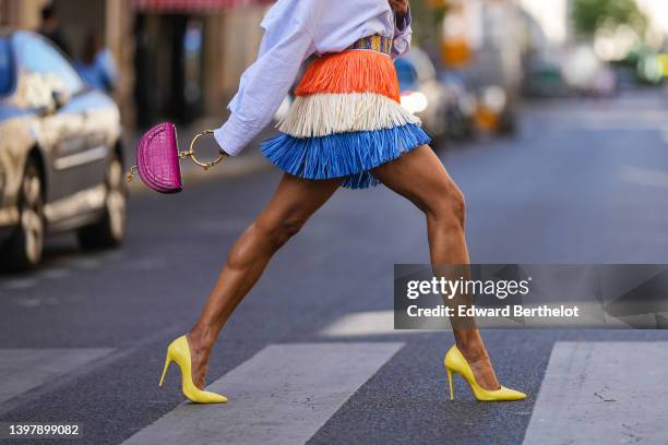 Emilie Joseph @in_fashionwetrust wears a blue / white / orange fringed made from natural raffia by Stella Jean for Desigual, a neon pink shiny...
