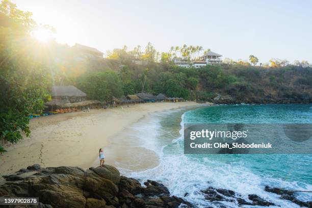 woman standing on the beach in puerto escondido - playa del carmen stock pictures, royalty-free photos & images