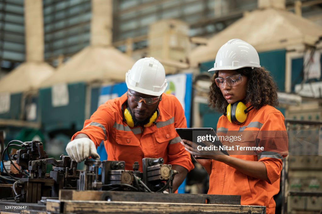 Process Audit of Jig and Fixture for Assembly Line. African American Mechanical Engineers are working together to inspect of welding jig assembly based on the process control plan in a production line.