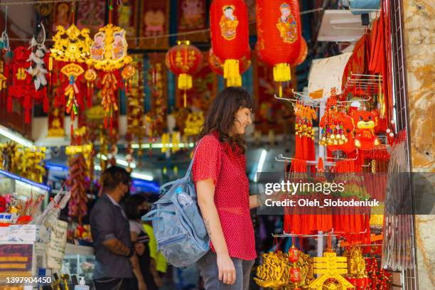 woman choosing souvenirs in chinese shop - mexican street market stock pictures, royalty-free photos & images