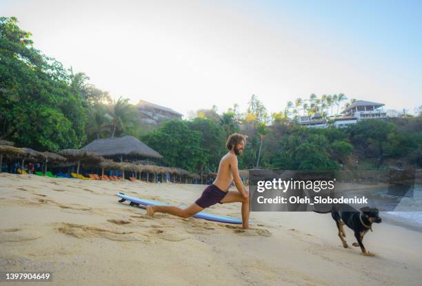 man surfing in puerto escondido  beach at sunset - puddling stockfoto's en -beelden