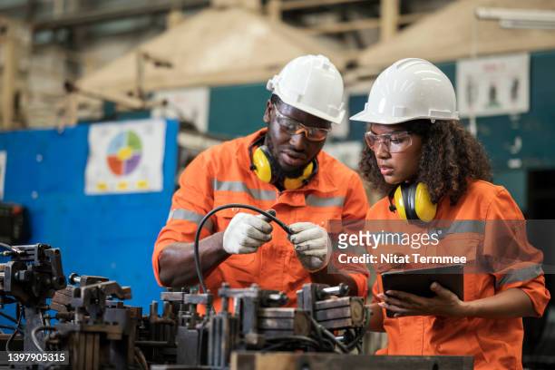 alignment and assembly jigs developed to boost quality and efficiency in an auto parts manufacturing industry. two african american process engineers discussions on assembly jig and verify the dimensional accuracy of the fixture to increase durability. - apprenticeships stock pictures, royalty-free photos & images