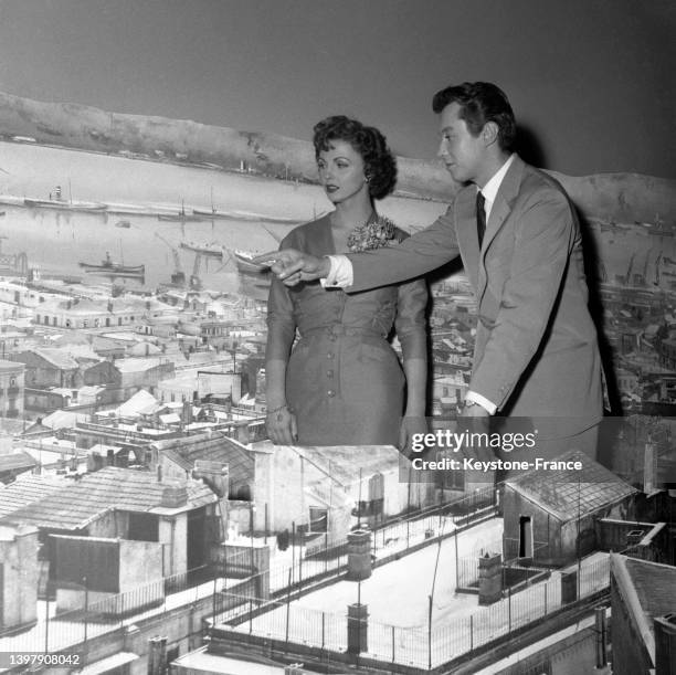 Madeleine Lebeau et Michel Auclair au milieu d'un décors à l'effigie de Marseille sur le tournage du film 'Quai des blondes', le 27 novembre 1953.