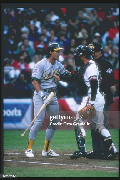 Catcher Terry Kenney of the San Francisco Giants and outfielder Jose Canseco of the Oakland Athletics exchange words during a playoff game at...