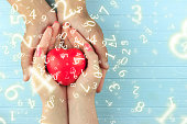 numerology, a heart in the hands of a girl in male hands, surrounded by numbers, the concept of love