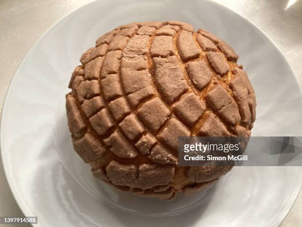 chocolate concha sweet bun on a white plate at an outdoor cafe - sweet bread fotografías e imágenes de stock