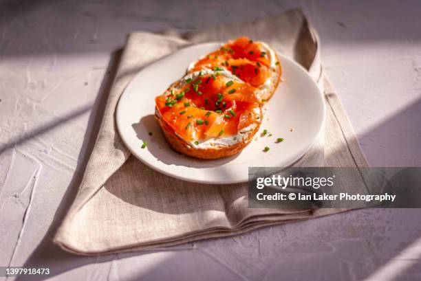 littlebourne, kent, england, uk. 12 may 2022. freshly baked sliced bagels. - chewy foto e immagini stock