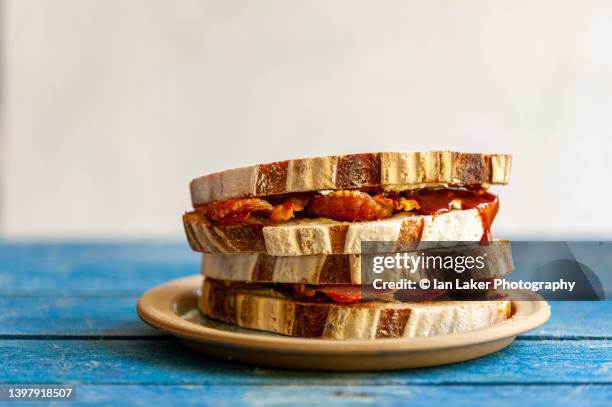 littlebourne, kent, england, uk. 13 may 2022. bacon sandwich with brown sauce. - bacon imagens e fotografias de stock