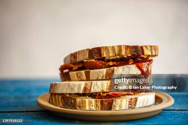 littlebourne, kent, england, uk. 13 may 2022. bacon sandwich with brown sauce. - bacon sandwich stock pictures, royalty-free photos & images