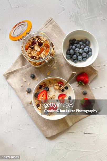 littlebourne, kent, england, uk. 13 may 2022. granola breakfast cereal with fresh strawberries and blueberries. - strawberry texture stock pictures, royalty-free photos & images