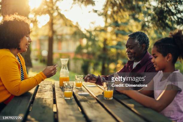 afroamerikanische großeltern spielen karten mit ihrer enkelin - card game mature people stock-fotos und bilder