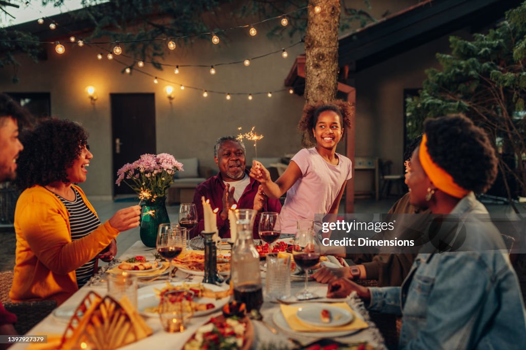 Big family garden party celebration, gathered together at the dining table outdoors