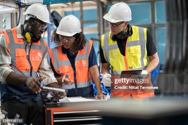 reduce manufacturing waste solution. group of manufacturing process engineers having a discussion about welding assembly process improvement to reduce parts defect during production in front of the production line. - gewerkschaft stock-fotos und bilder