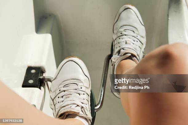 women's legs in sneakers on the pedals of a catamaran. boat trip on the lake or sea in sunny weather in summer. - pedal boat photos et images de collection