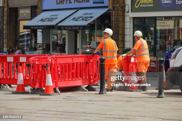 workmen repairing the pavement and roads in the centre of the cotswold market town of cirencester in gloucestershire - road work stock pictures, royalty-free photos & images