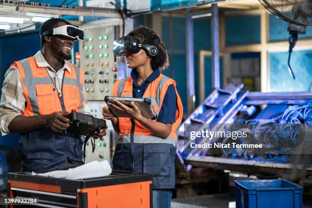 optimize production line design with simulation modeling for manufacturing industry. mechanical and production engineers in an engineering parts assembly line. they are using vr glasses to simulation assembly welding before starting the actual production - modeling and simulation stock pictures, royalty-free photos & images