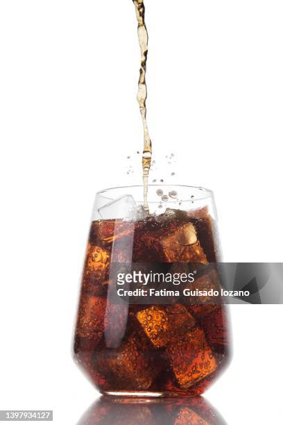 glass of cola with ice and soft drink is being poured into the glass. - coca cola photos et images de collection