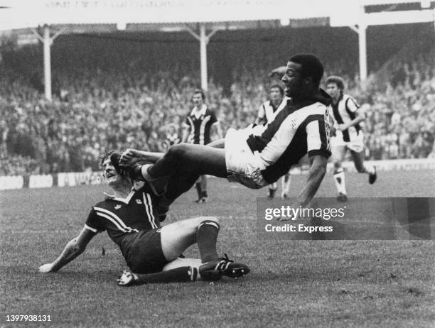 English soccer player Cyrille Regis of West Bromwich Albion FC, in an attempt to catch the ball, accidentally hits Scottish soccer player Gary...