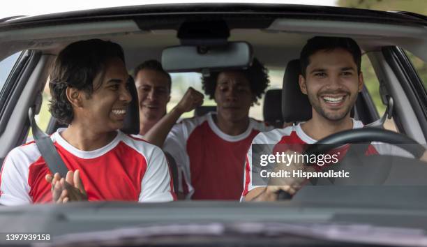 happy group of soccer players driving to practice in a car - stemdistrict stockfoto's en -beelden