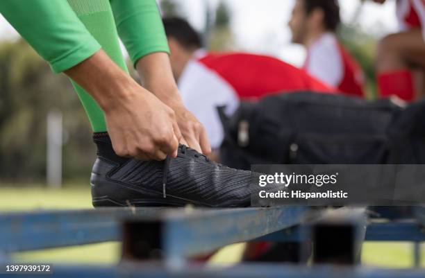 primer plano de un jugador de fútbol atándose el cordón de los zapatos - subs bench fotografías e imágenes de stock