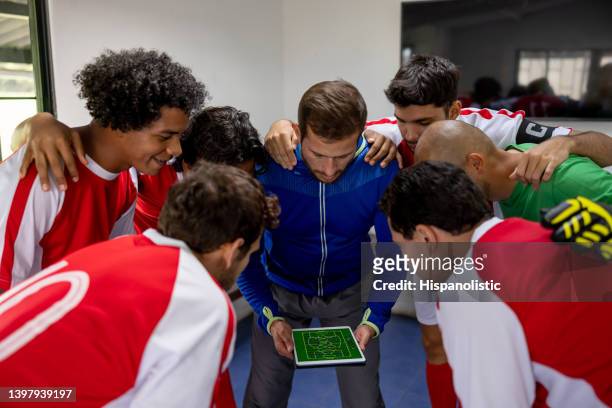 entrenador de fútbol hablando con su equipo sobre su estrategia para el juego - half time fotografías e imágenes de stock