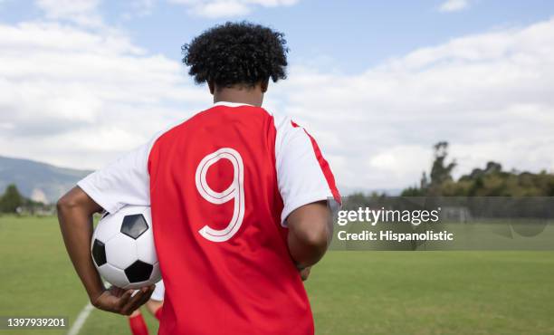 football player holding the ball while entering the field to play - side lines stockfoto's en -beelden