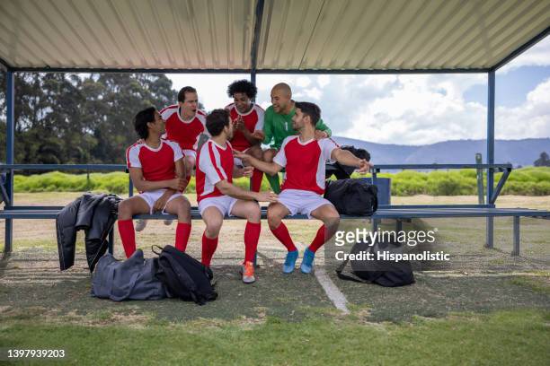 happy football team talking on the bench before the game - fotbollsmästerskap bildbanksfoton och bilder